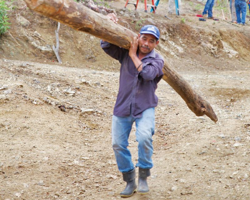 Closeup of villager carrying utility pole