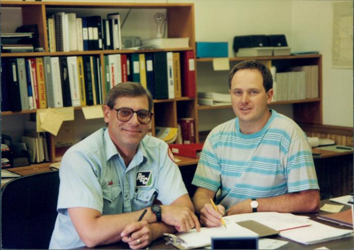 John Tegler with a co-worker at a desk